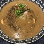 Photo of creamy mushroom soup with pea garnish