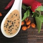 Image of salad dressing with Thai basil, peanuts and a red pepper