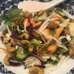 Image of a salad with papaya, cabbages, spicy Thai cashews