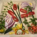 Image of vegetables appearing as flowers on a bechamel topped ratatoille